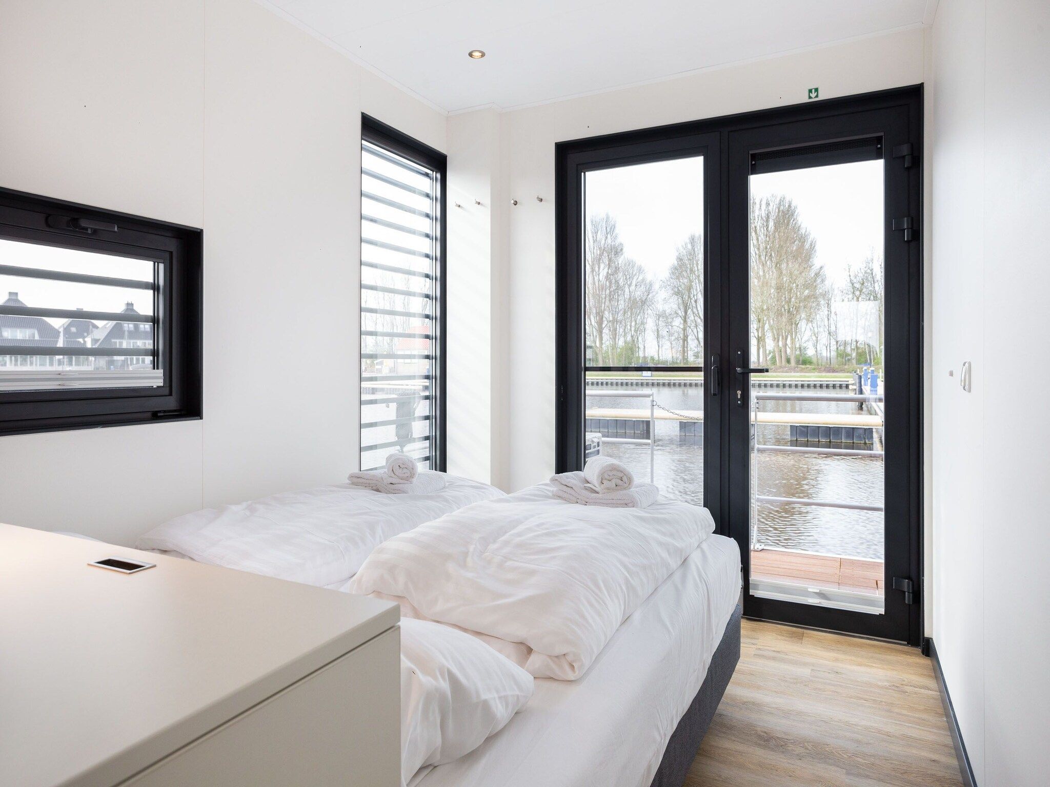 Een slaapkamer van Houseboat 'de Valreep' met tuin - Paviljoenwei 2 in Offingawier