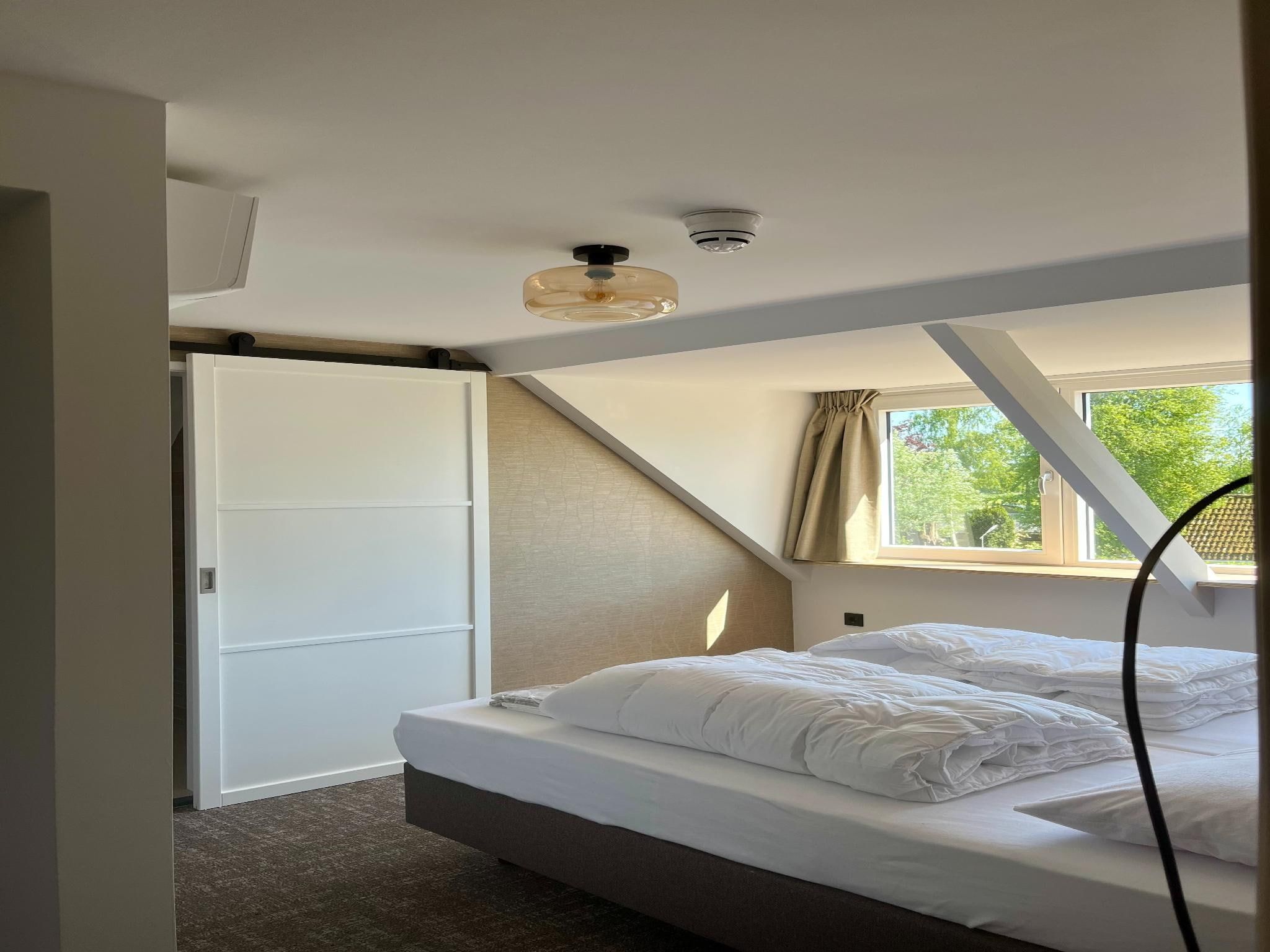 Een slaapkamer van Groepsaccommodatie voor 20 personen + 5 Tiny Greenhouses voor 2 tot 4 personen in Scherpenzeel (FR)