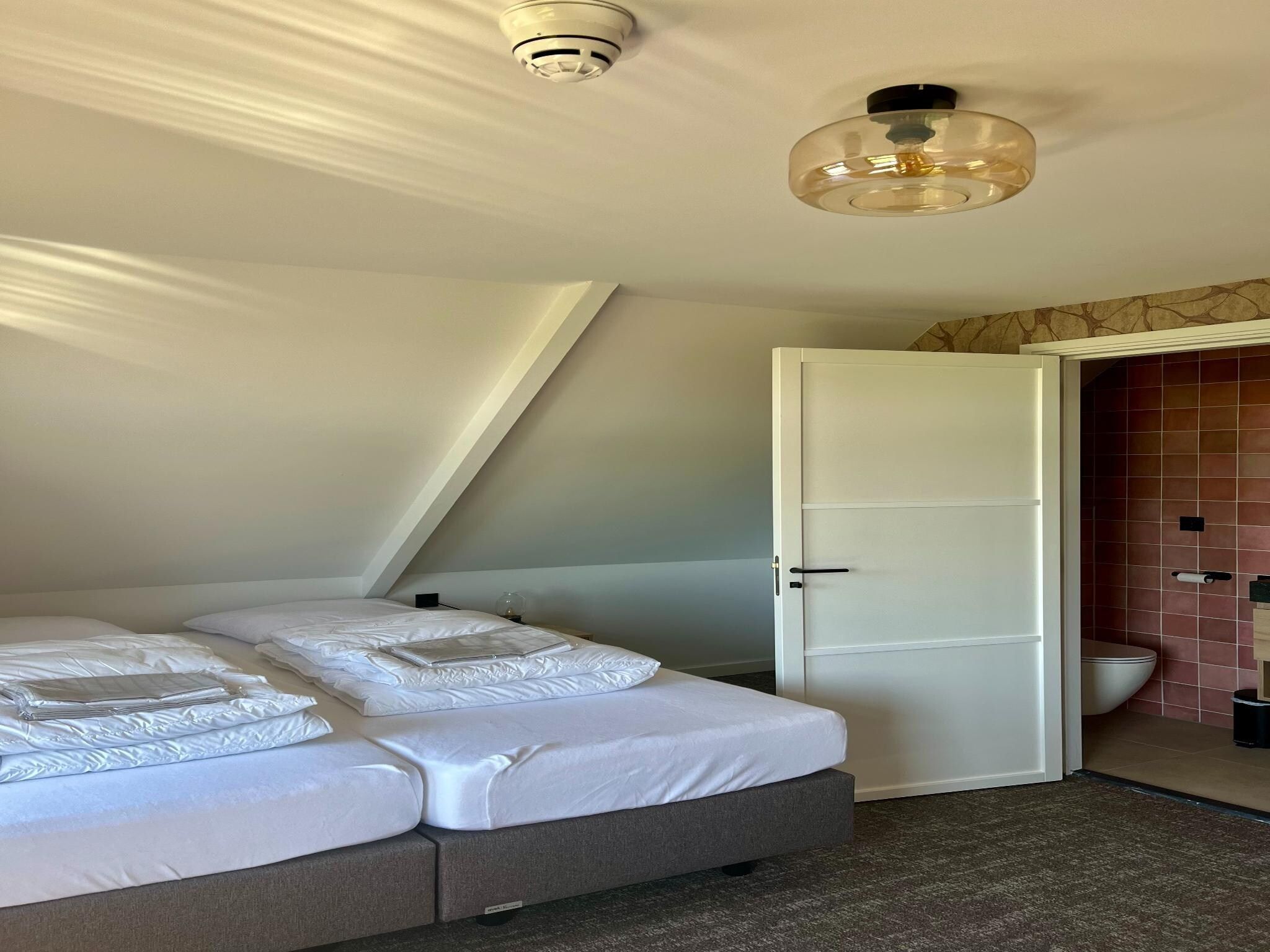 Een slaapkamer van Groepsaccommodatie met 10 luxe tweepersoons kamers in Scherpenzeel
