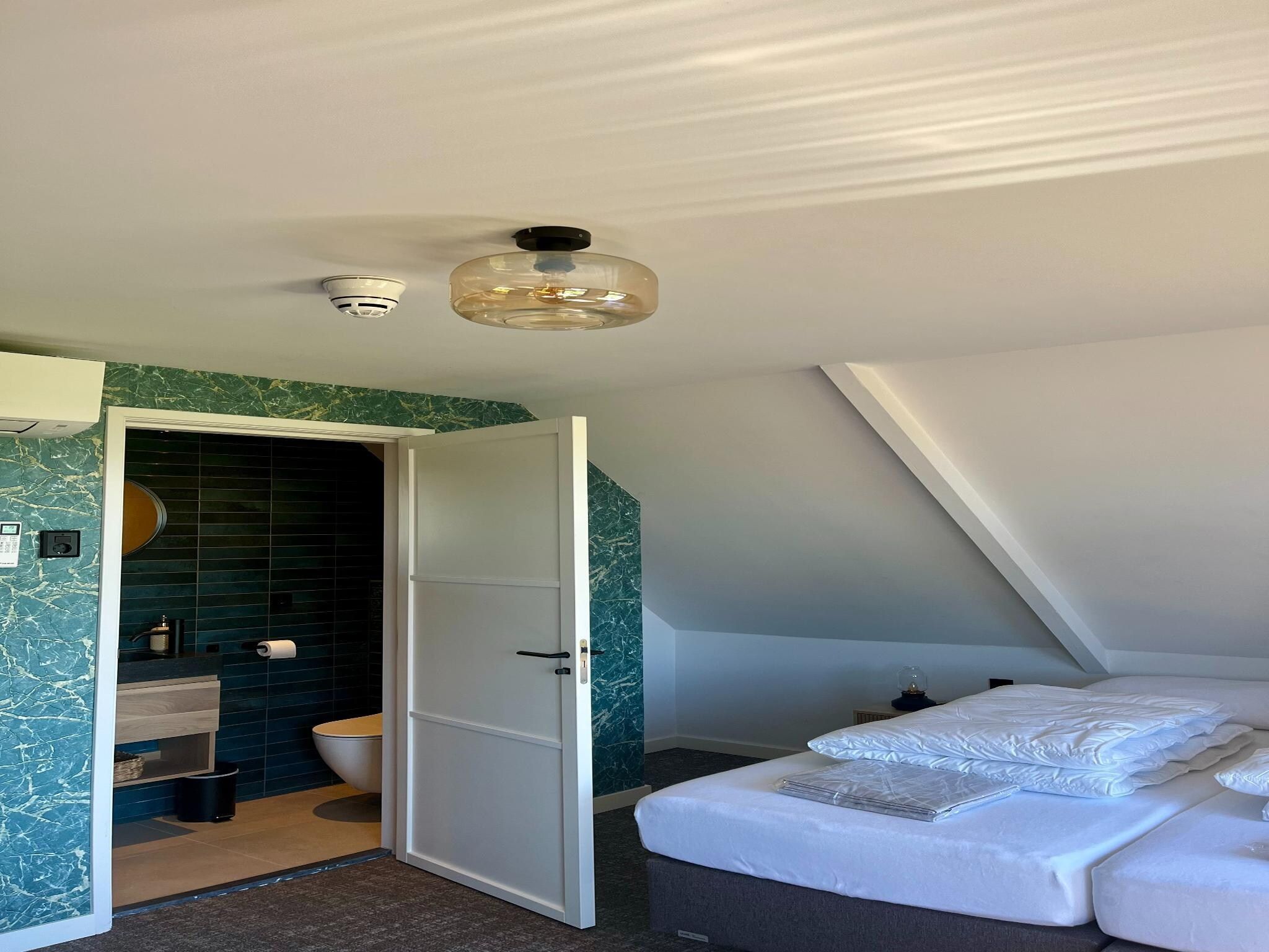Een slaapkamer van Groepsaccommodatie met 10 luxe tweepersoons kamers in Scherpenzeel