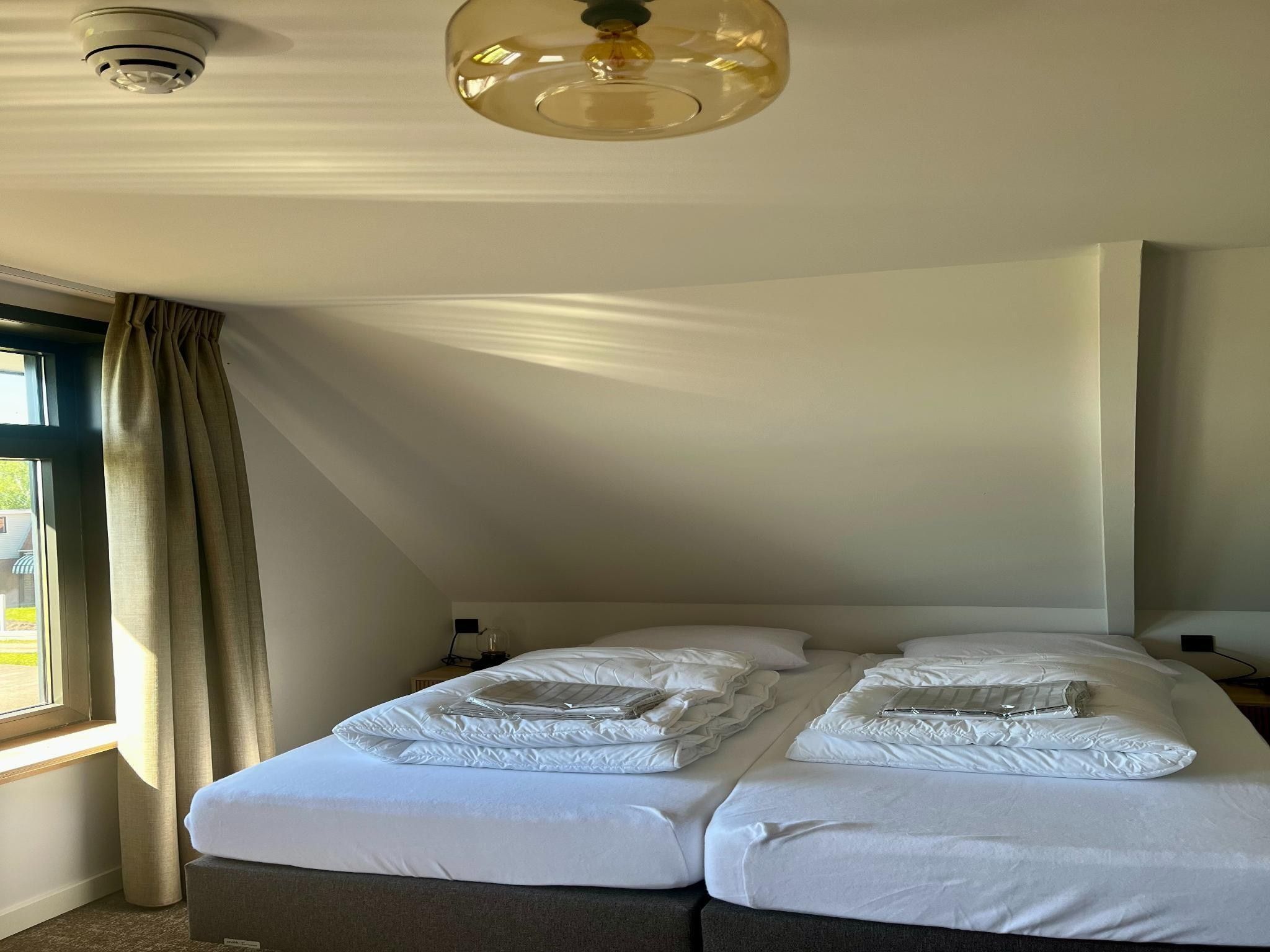 Een slaapkamer van Groepsaccommodatie met 10 luxe tweepersoons kamers in Scherpenzeel