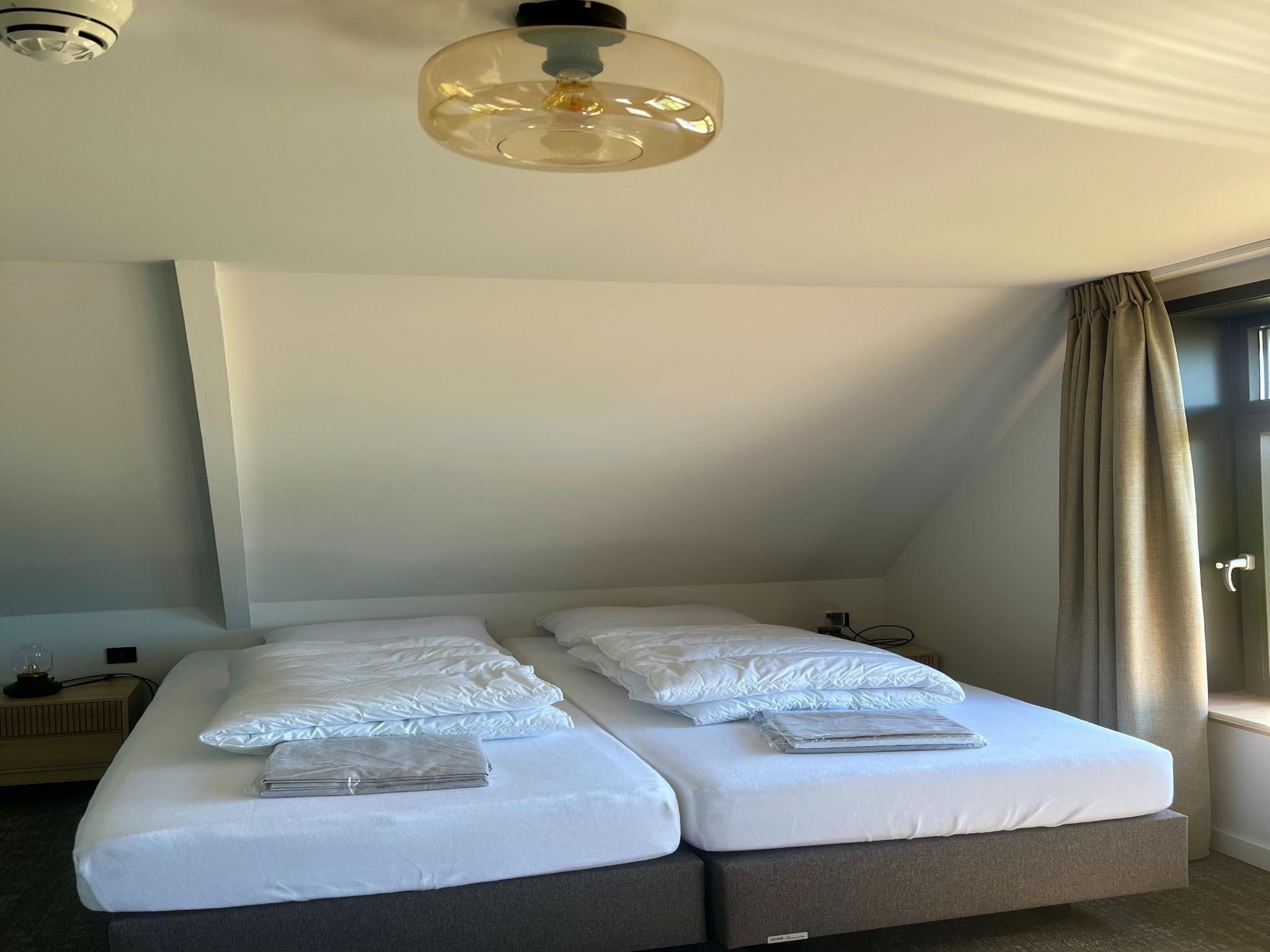 Een slaapkamer van Groepsaccommodatie met 10 luxe tweepersoons kamers in Scherpenzeel