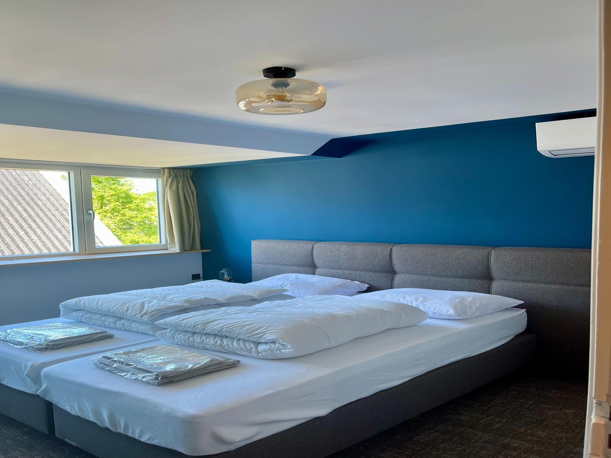 Een slaapkamer van Groepsaccommodatie met 10 luxe tweepersoons kamers in Scherpenzeel