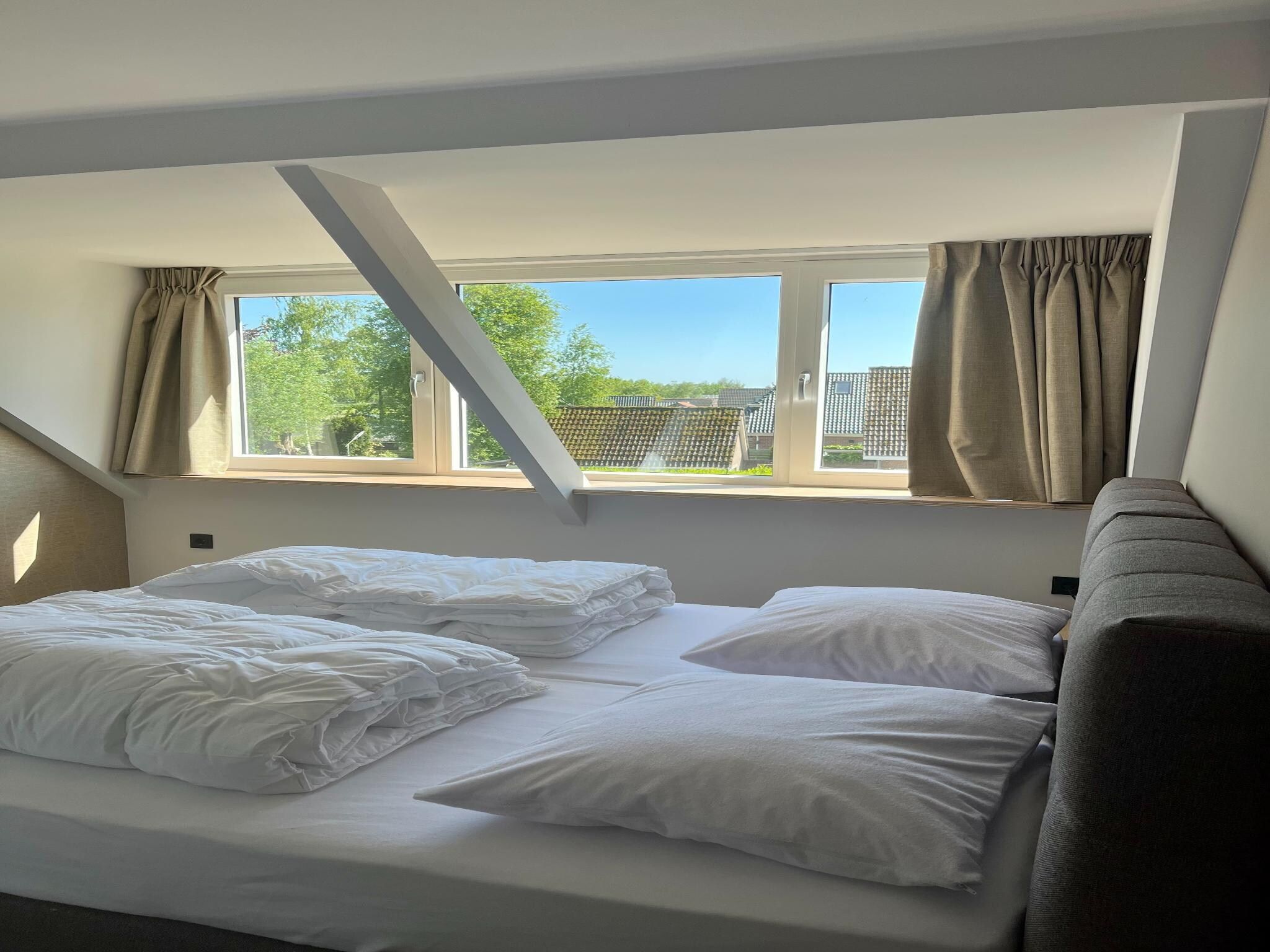 Een slaapkamer van Groepsaccommodatie met 10 luxe tweepersoons kamers in Scherpenzeel