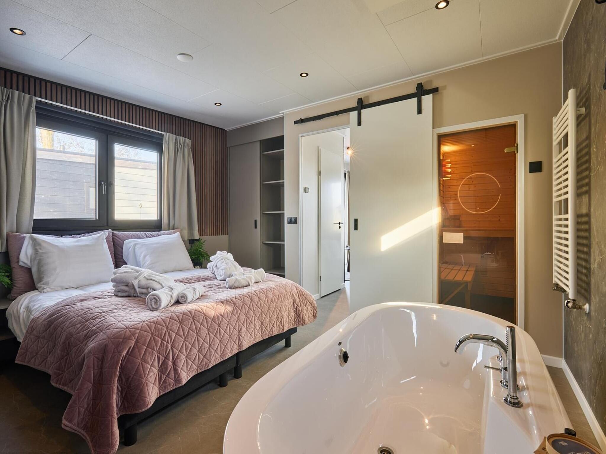 Een slaapkamer van River Lodge 'Wellnesshuus' with whirlpool, sauna, bathtub, and sun shower | 2 people in Zuna