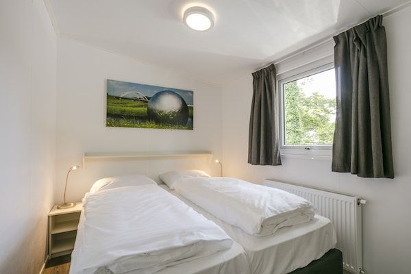 Slaapkamer - Zonovergoten chalet bij de vijver in Lochem (4)