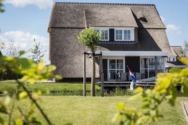 Buitenkant - Villa aan het meer met terras in Delfstrahuizen (1)
