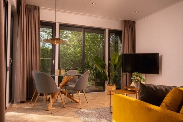 Woonkamer - Elegant houten vakantiehuisje voor 4 personen met bubbelbad in Rijssen (5)