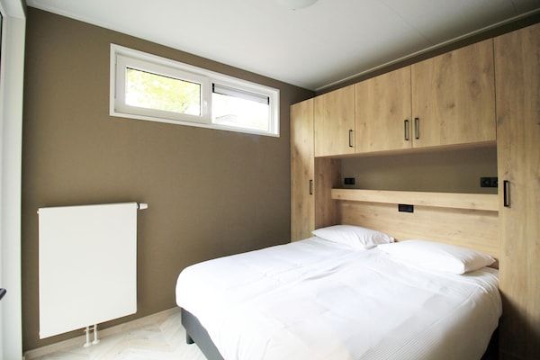 Slaapkamer - Modern huisje met uitzicht op het meer op de Veluwe in Hoenderloo (3)