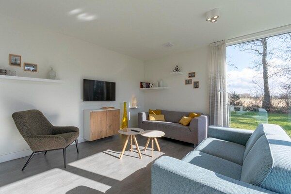 Woonkamer - Bungalow bij strand en bollenvelden in Sint Maartensvlotbrug (2)