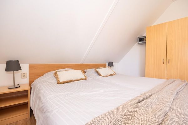 Slaapkamer - Vrijstaande groepsaccommodatie voor 12 personen met tuinkamer en houtkachel in Andijk (5)