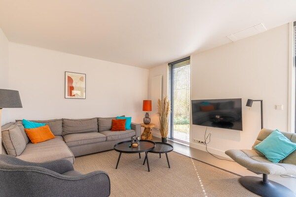 Woonkamer - Luxe 6 persoons vakantiehuis gelegen aan de rand van het bos in Den Burg (5)