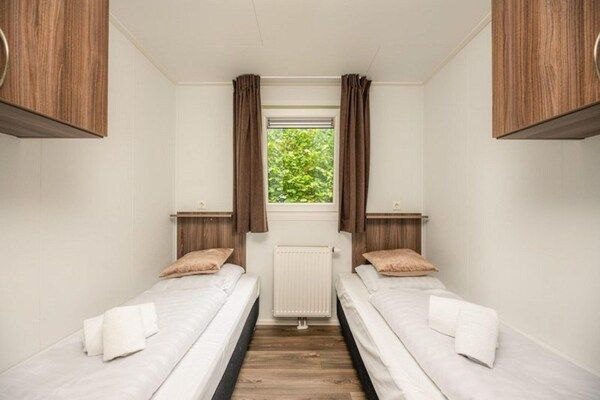 Slaapkamer - Schilderachtige boslodge nabij Holterberg met uitzicht op het water in Rijssen (4)